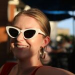 woman in red tank top wearing white framed sunglasses